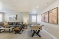 Basement recreation room with a foosball table, a gray sectional sofa, and a three-panel canyon wall art display.