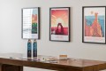 Wooden table with two blue bottled drinks and scattered board game pieces, against a wall with three framed travel posters (Reef, Arches, Bryce Canyon).