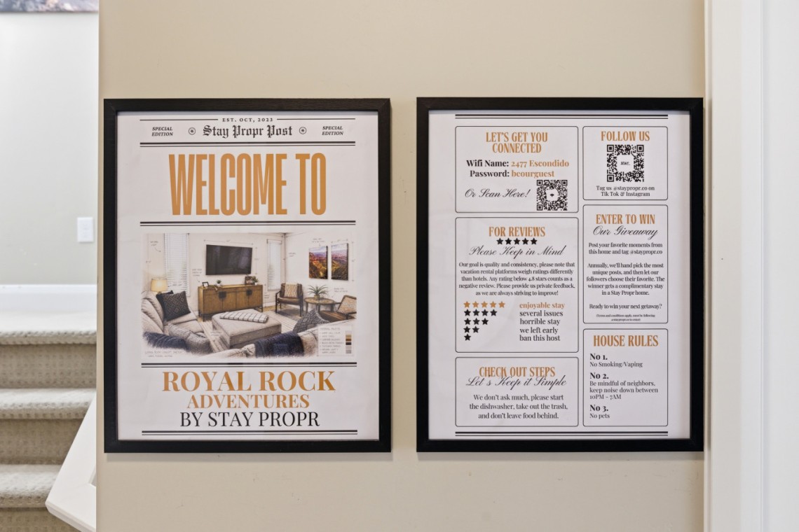 Two framed posters mounted on a beige wall; left one says 'WELCOME TO ROYAL ROCK ADVENTURES BY STAY PROPR' with a living room image, right one lists guest info like Wi‑Fi and house rules as sections.