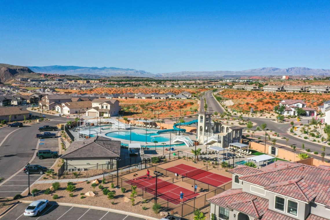 Suburban recreation center with a large pool, water slides, and surrounding townhomes in a desert community.
