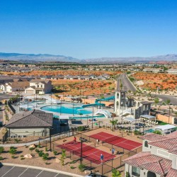 Suburban recreation center with a large pool, water slides, and surrounding townhomes in a desert community.