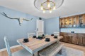 Blue-dk dining room with a rustic wooden table, bench seating, and a longhorn skull wall decor above one wall