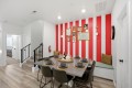 Dining area with red and white striped accent wall, gallery wall, built-in bench, and a table set for eight.